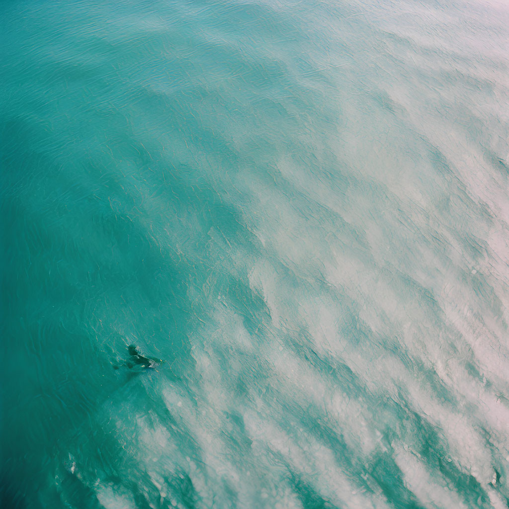 Aerial View of Person Surfing on Vibrant Blue Waters