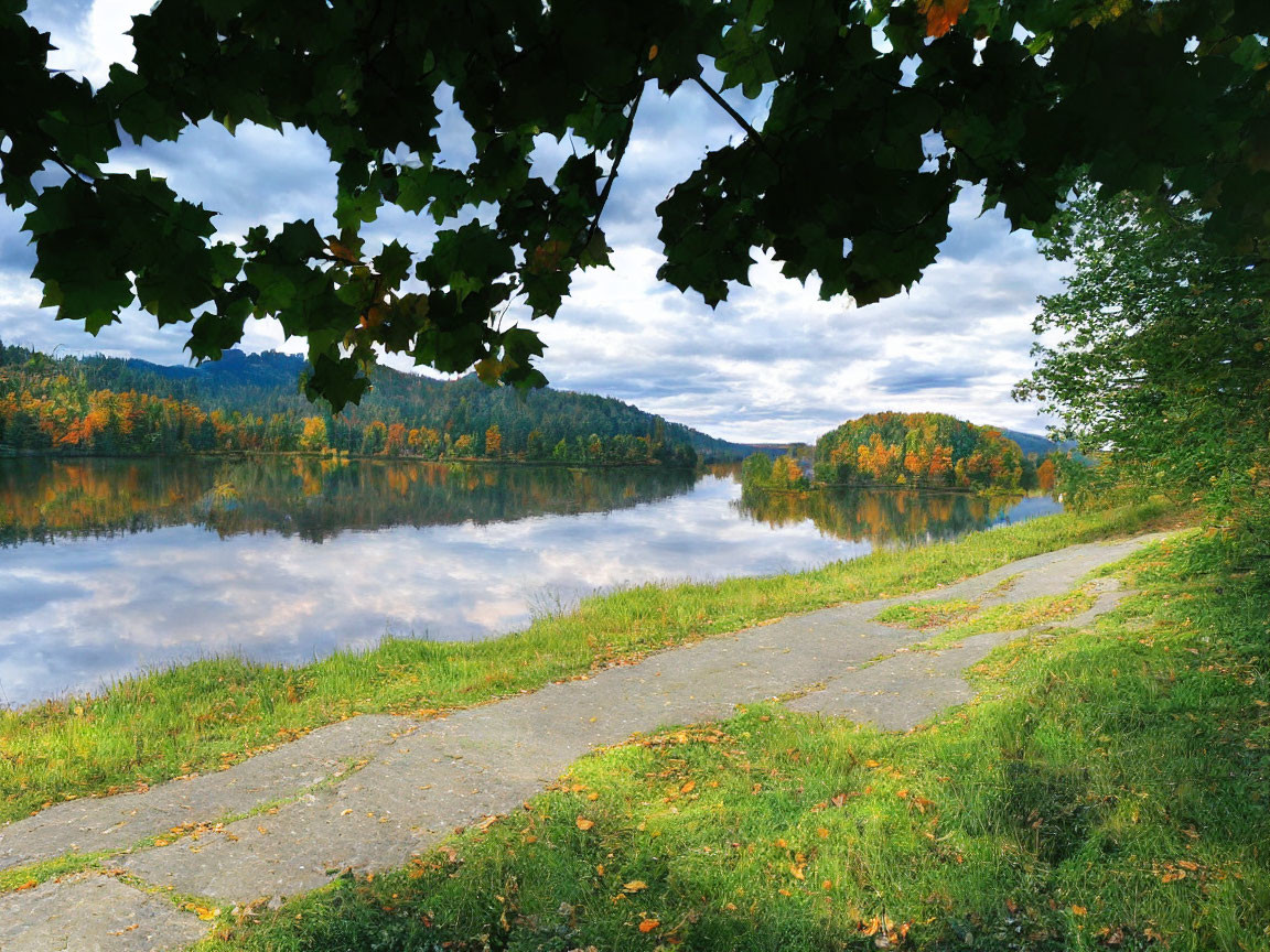 Tranquil lake scene with autumn trees and walking path