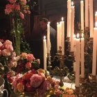 Vibrant roses and lit candles on candelabra still life display