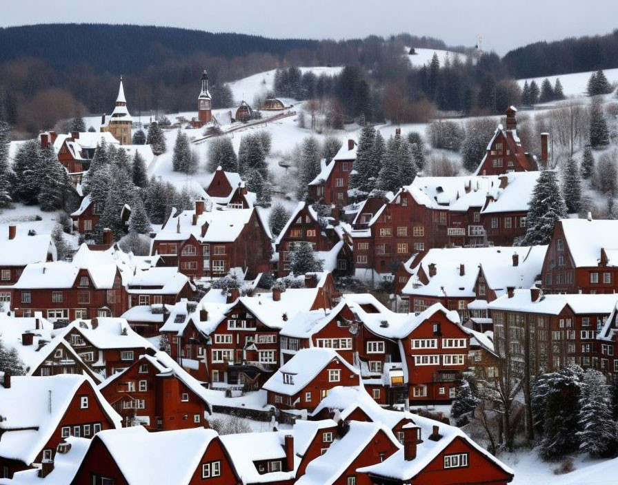 Snow-covered village with red-roofed houses, trees, and church in hills