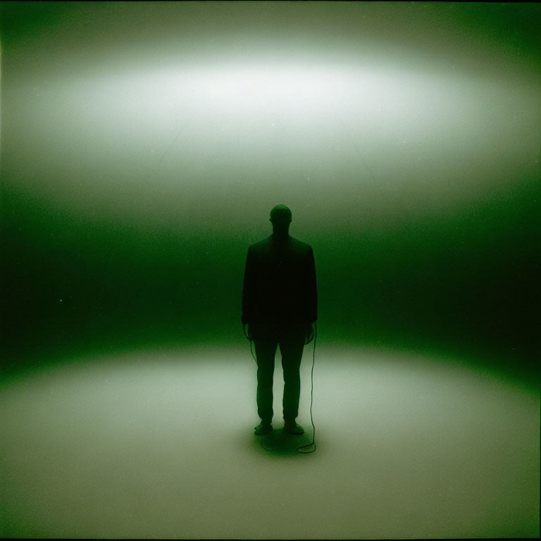 Silhouette of a Person Against Glowing Green Background