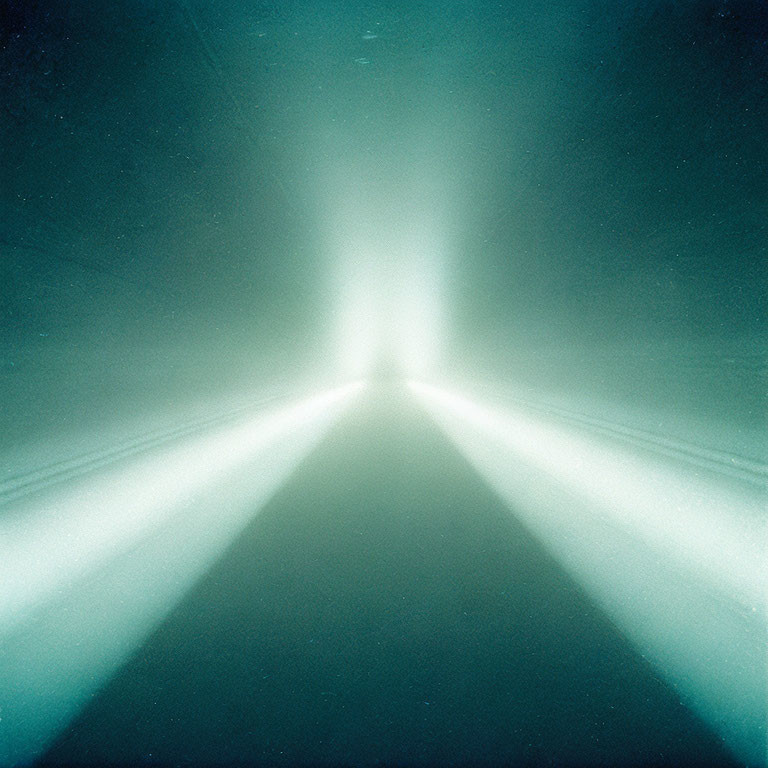 Abstract image: Beams of light converge on bright center