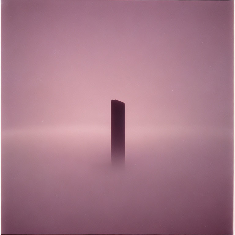 Dark Monolith in Misty Pink Landscape with Gradient Sky