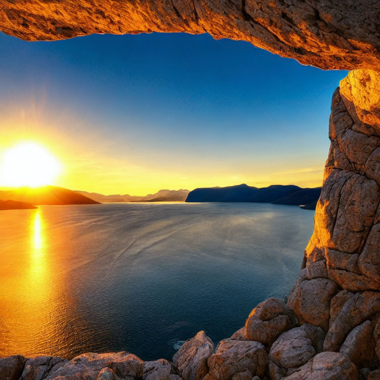 Scenic sunset view of calm sea and rugged cave entrance