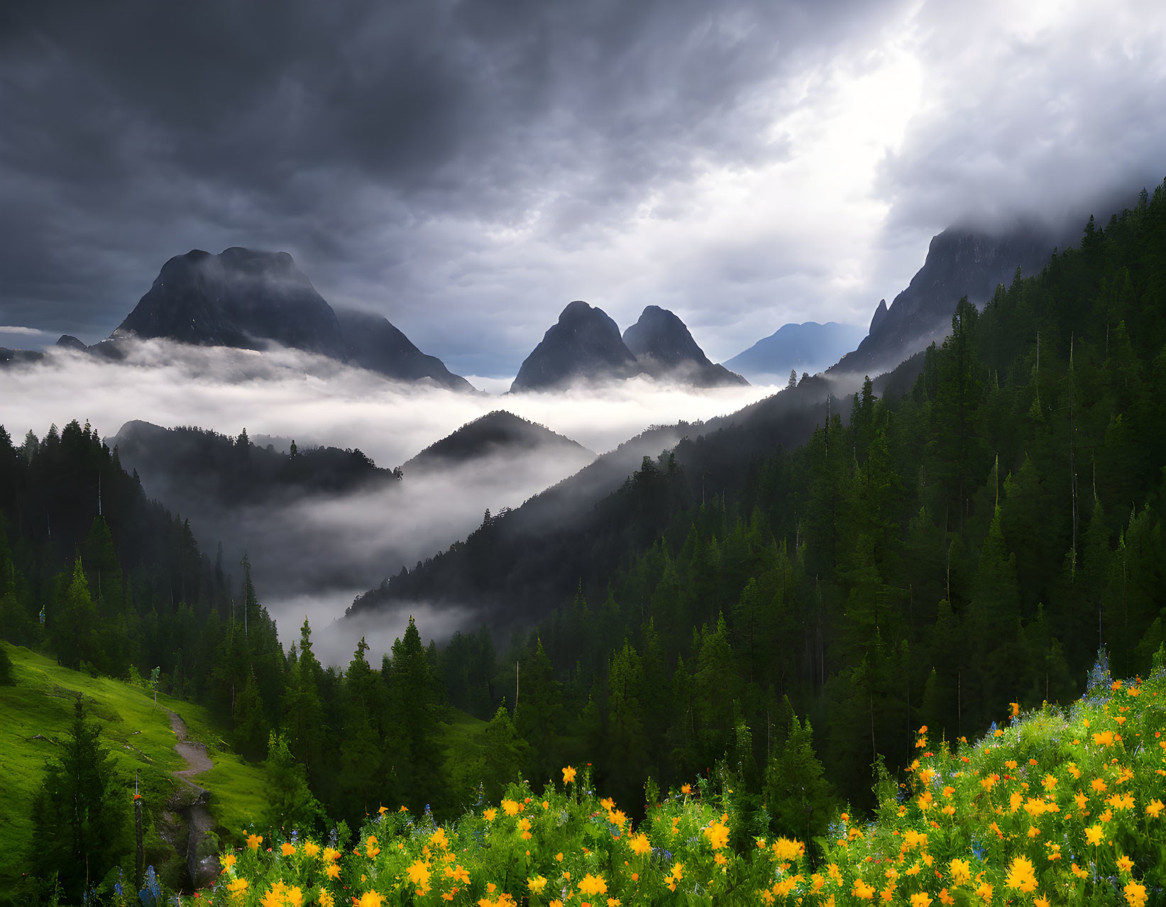 Majestic mountain landscape with fog, forests, wildflowers, and cloudy sky