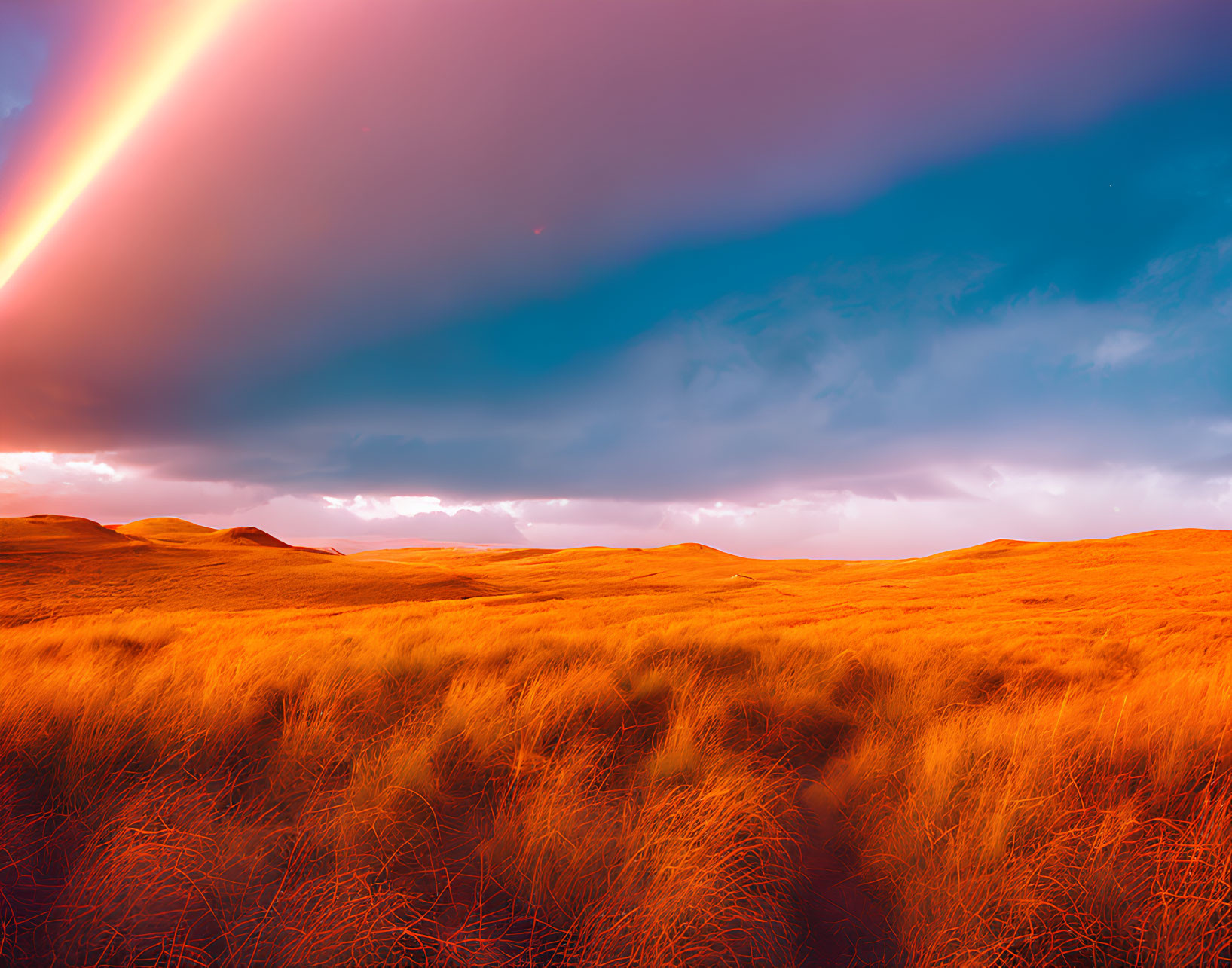 Dramatic sky with vivid orange grassland and bright light streak