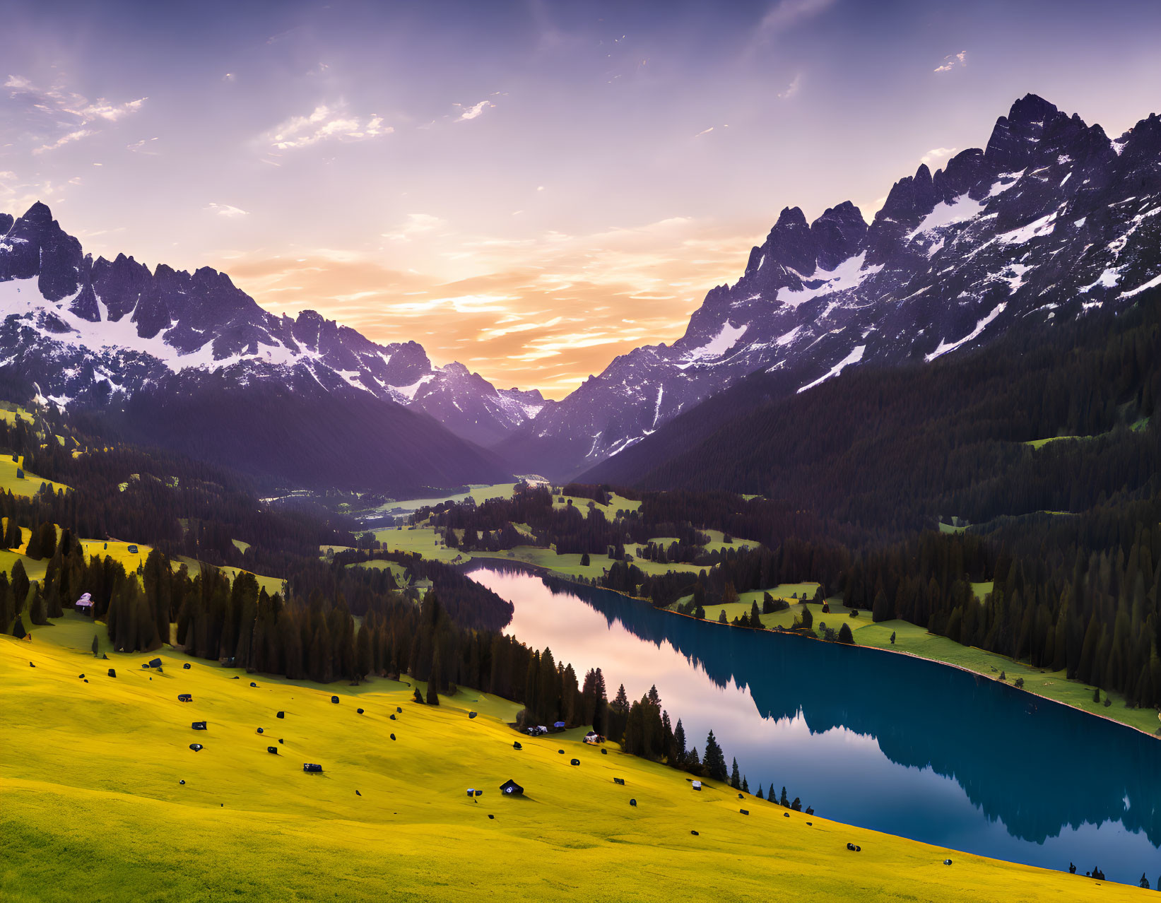 Tranquil mountain sunset with lake, meadows, cattle, and vibrant sky