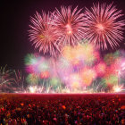 Colorful fireworks display: pink, green, and red bursts in night sky