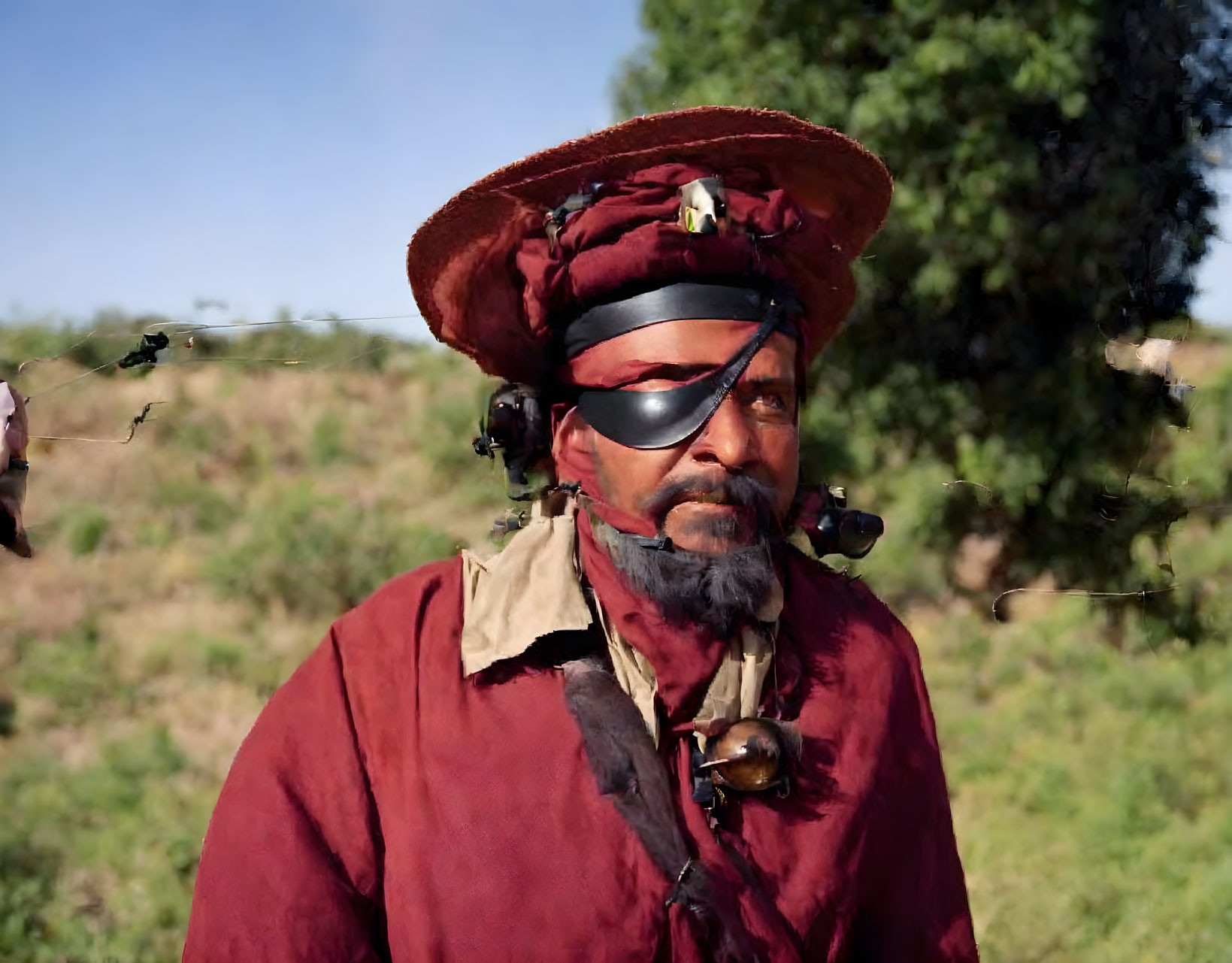 Man in Burgundy Hat and Shirt with Sunglasses and Mustache Outdoors