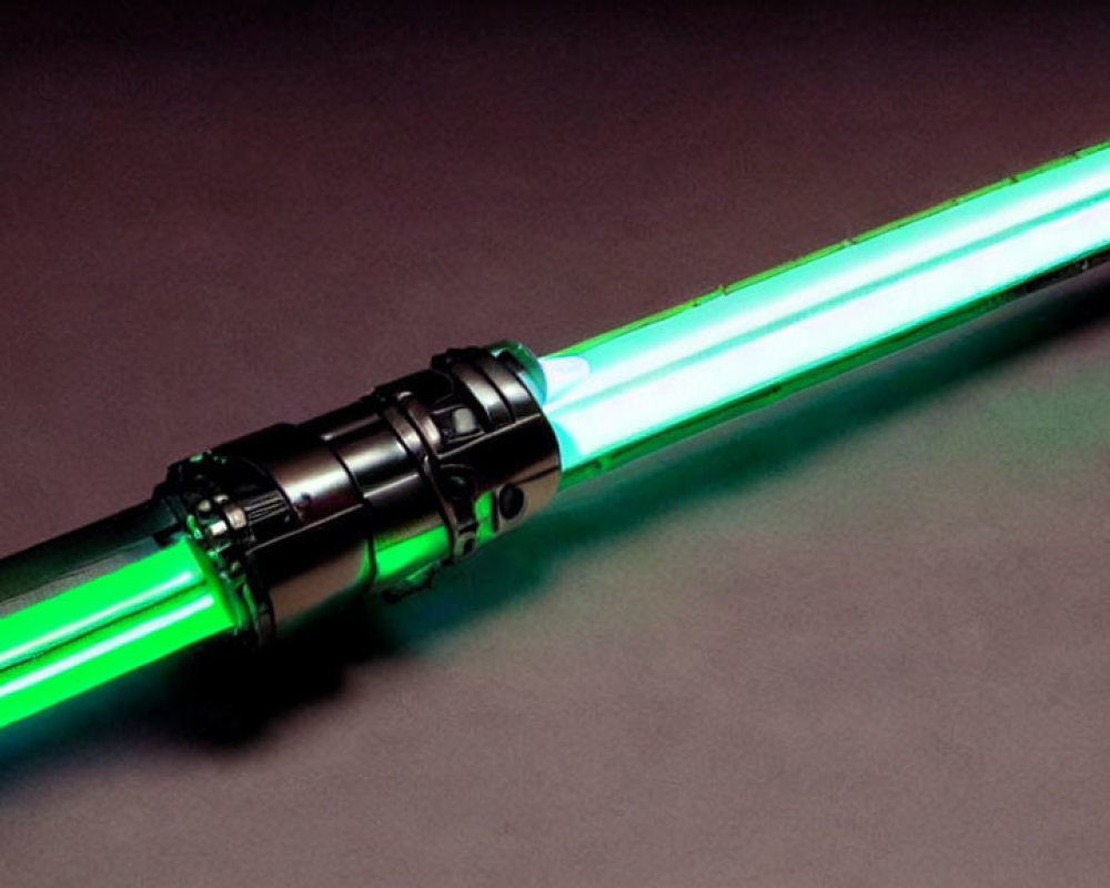 Green-bladed lightsaber with black hilt on dark surface