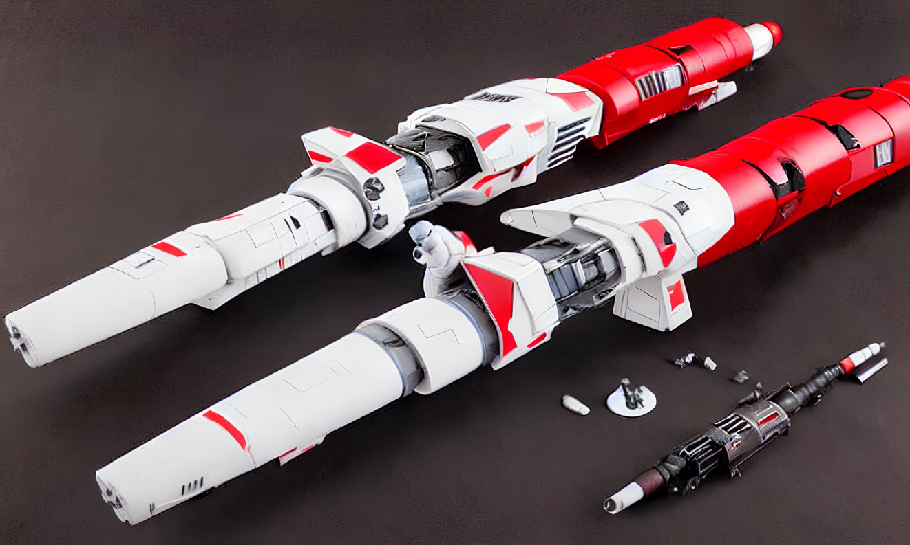 Detailed Red and White Model Spaceships Next to Dismantled Craft