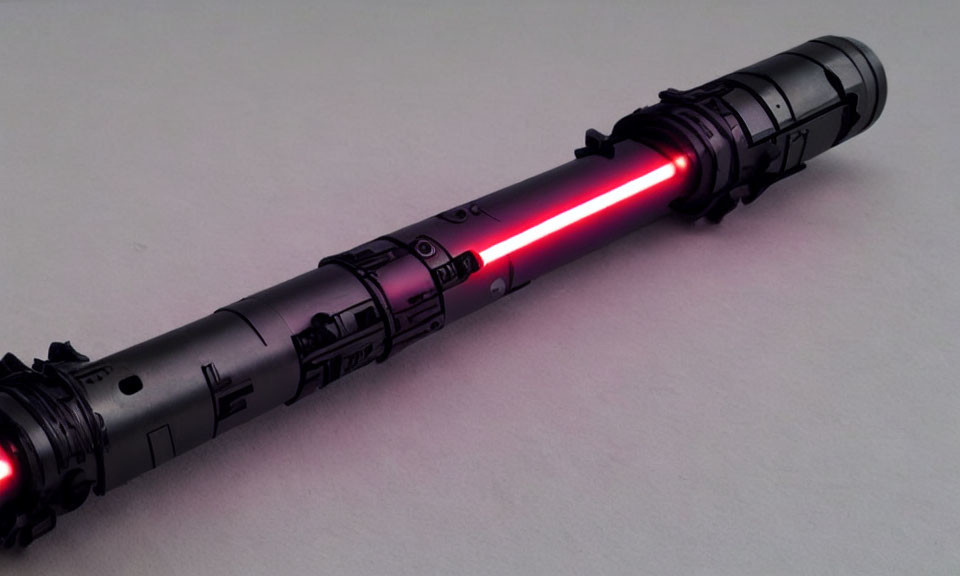 Black Hilt Lightsaber with Glowing Red Blade on Light Grey Background