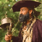 Man in pirate costume with tricorn hat, beard, and sword in hand against natural background