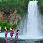 Vibrant painting of joyful dancing by waterfall with whimsical flamingos