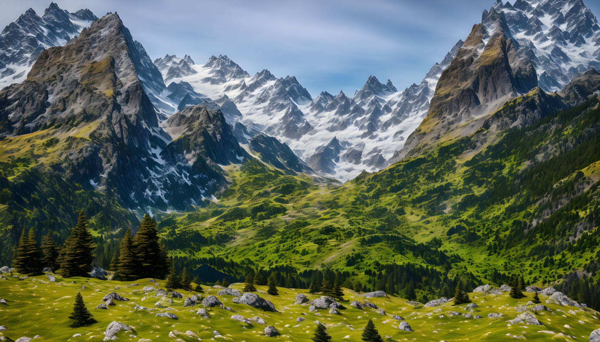 Snow-capped mountain range amidst green meadows and coniferous trees under cloudy sky