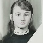 Portrait of young woman with blue eyes, dark hair, freckles, white turtleneck,