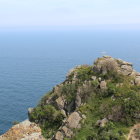 Golden-domed structure on lush islet in serene seascape