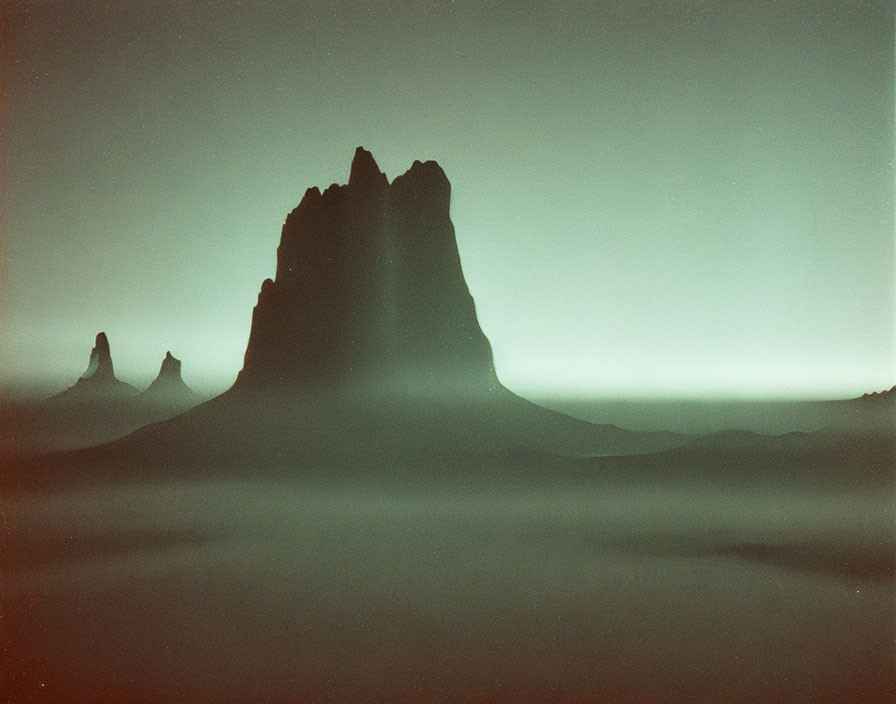 Rocky Peaks Silhouetted in Misty Landscape under Green Night Sky