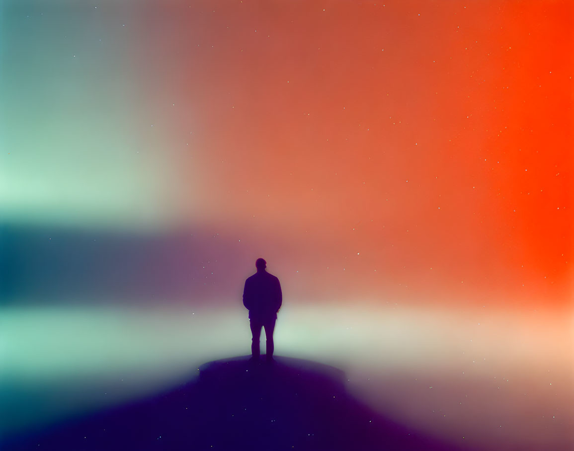 Silhouette of Person on Hill Against Vibrant Gradient Sky