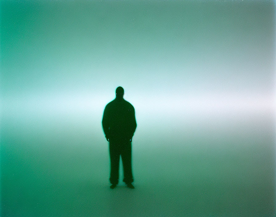Person's Silhouette in Hazy Green Room with Ethereal Light Gradient