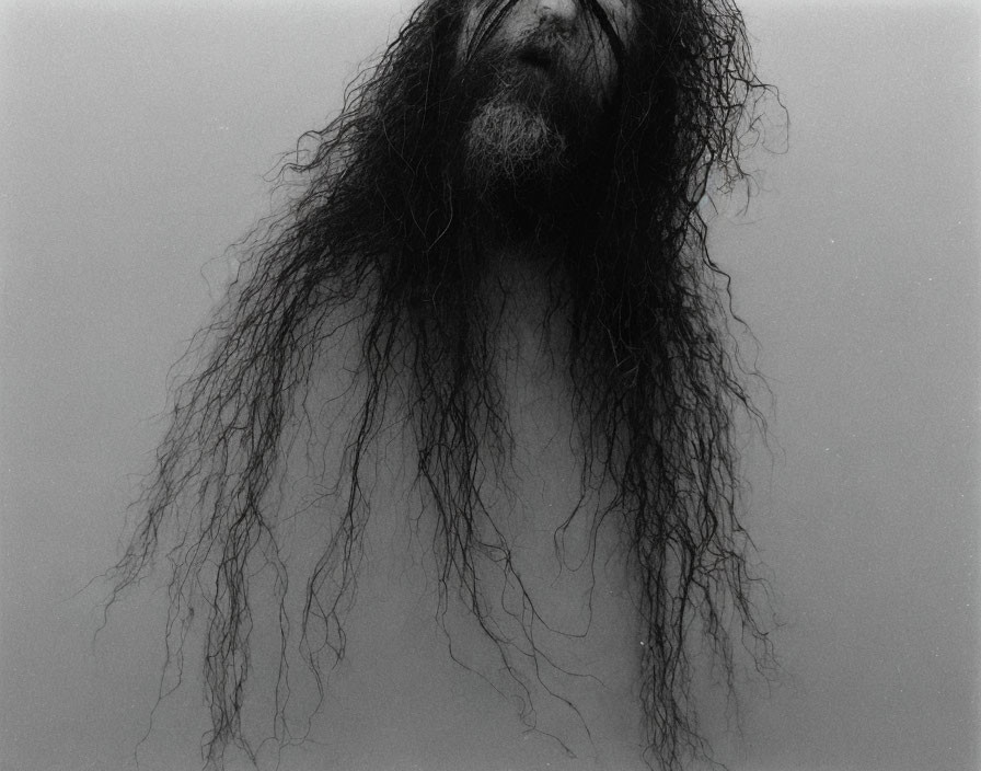 Monochrome portrait of person with long, wet hair obscuring face