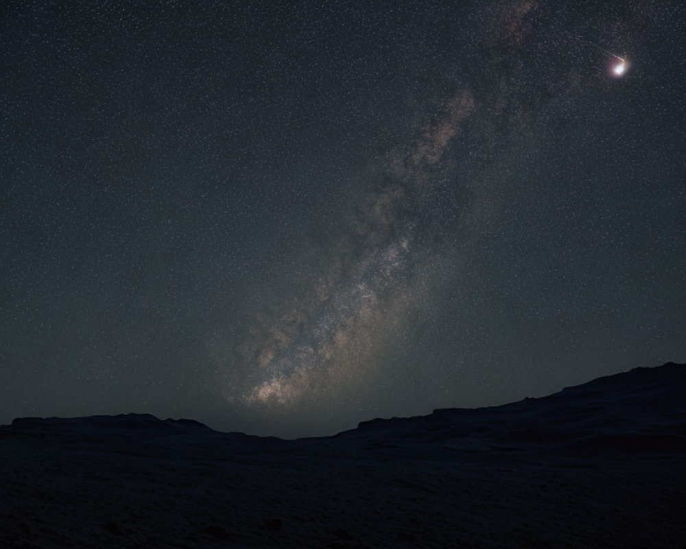 Starry night sky with Milky Way, crescent moon, and landscape.