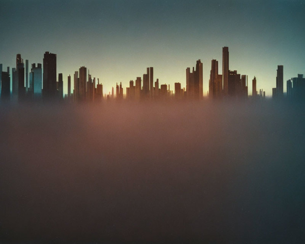 City skyline silhouette at twilight with orange and blue sky and mist-covered buildings