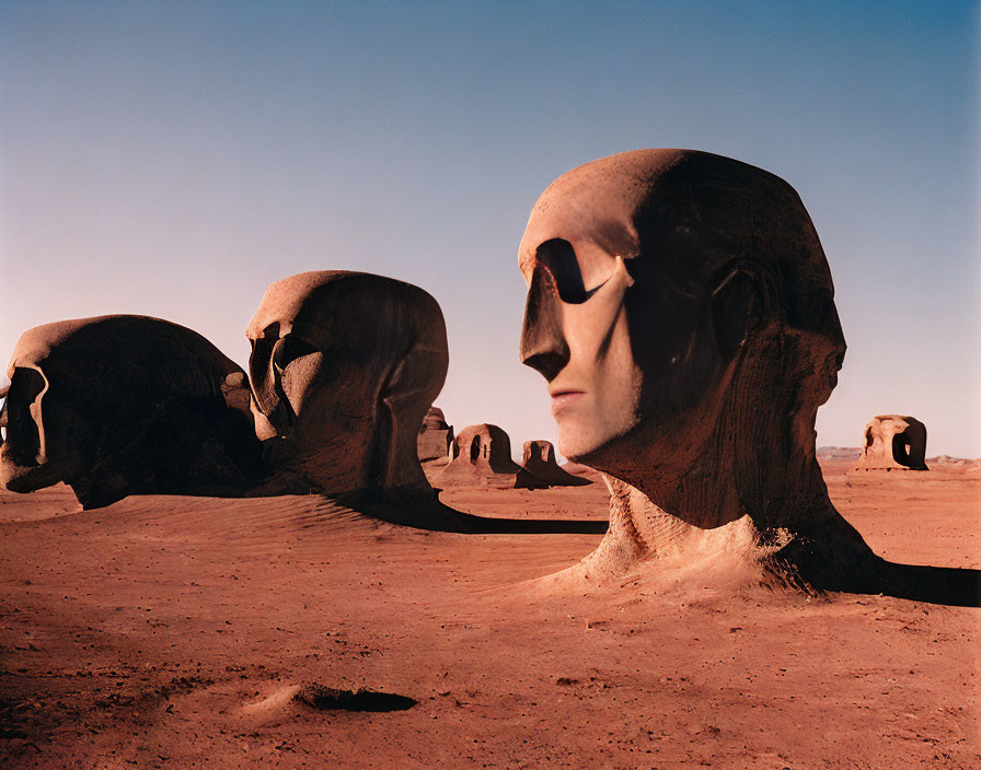 Colossal stone heads in surreal desert landscape