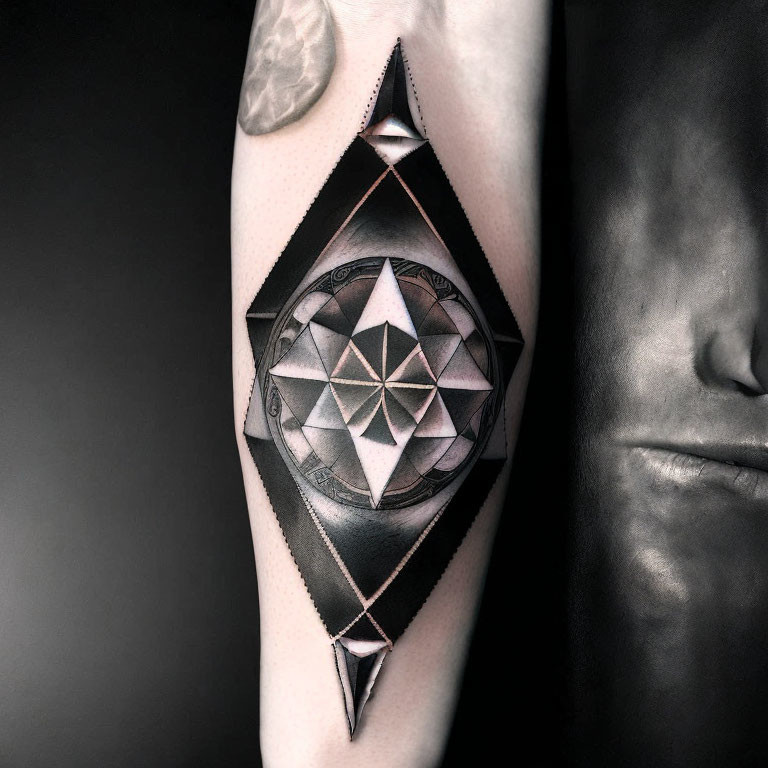 Monochromatic geometric tattoo with mandala in diamond shape on arm