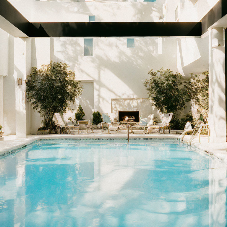 Luxurious Poolside with Lounge Chairs and Fireplace in White Architectural Setting