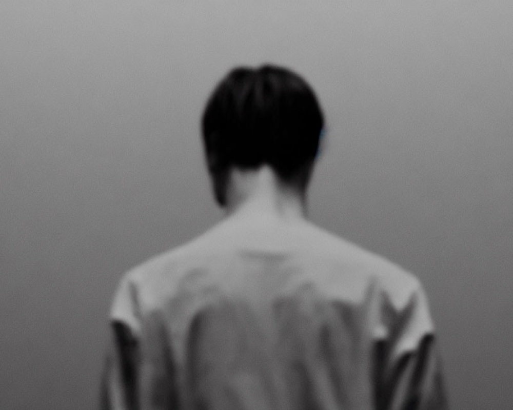 Monochrome image of person's back with blurry background