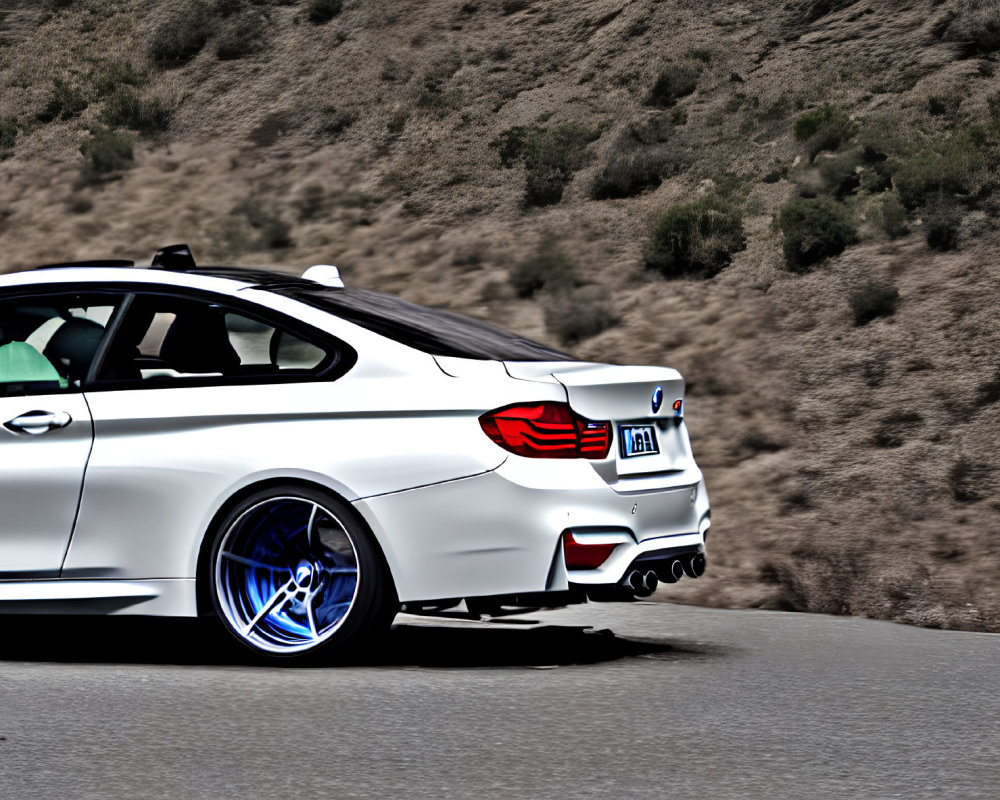 White Sports Car with Blue-Tinted Wheels on Mountain Road