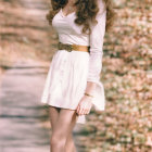 Blonde woman in vintage attire on forest path.