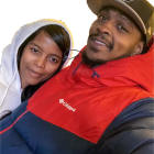 Smiling couple in winter attire close embrace with blurred background