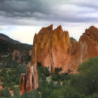 Majestic fantasy castle with spires and towers against mountain backdrop at sunset