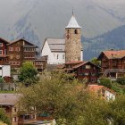 Rustic village with blooming gardens and snow-capped mountains