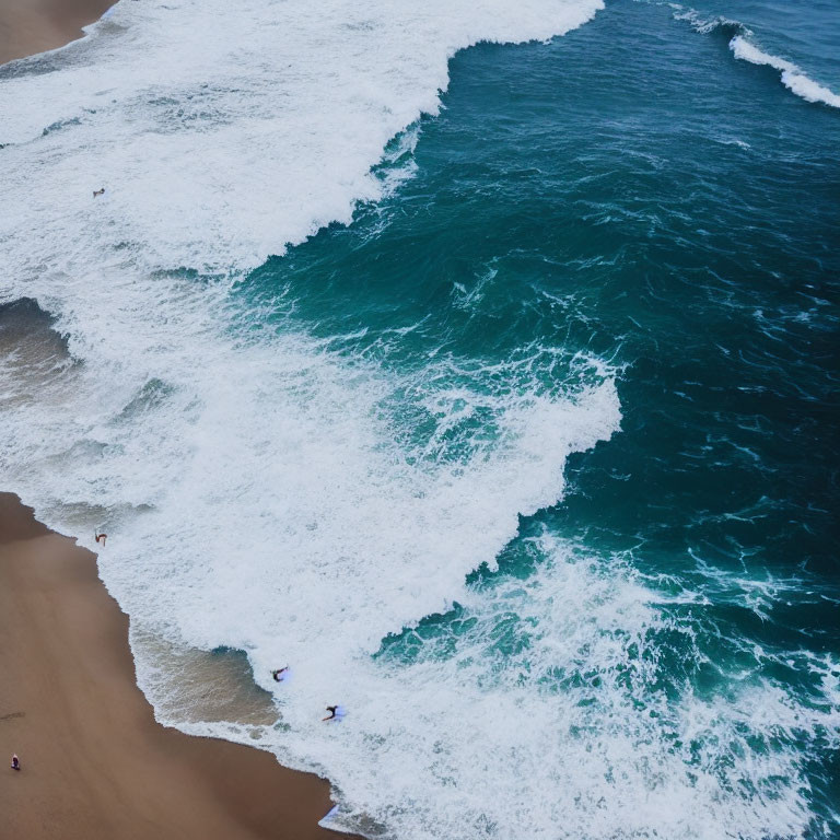 Aerial View of Shoreline with Frothy Waves and Figures