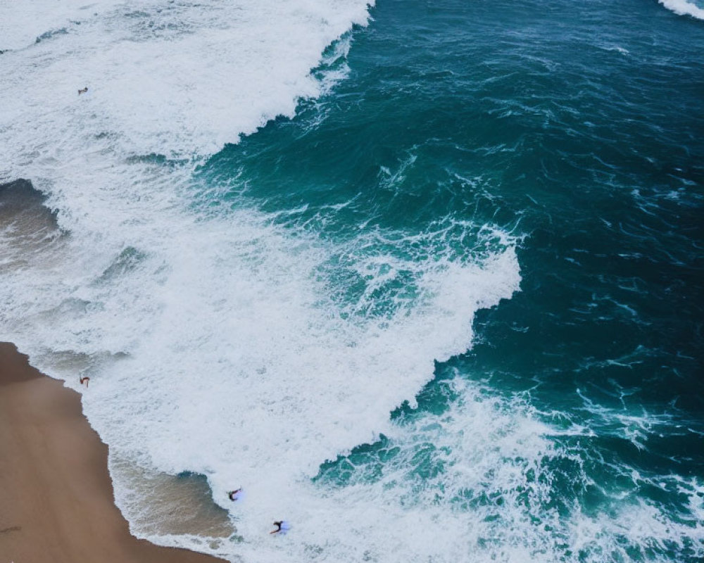 Aerial View of Shoreline with Frothy Waves and Figures