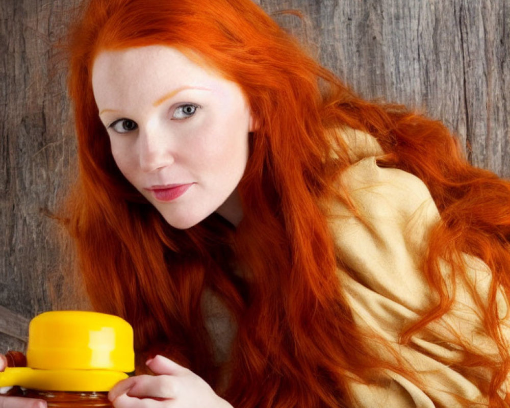 Red-haired woman with yellow object against rustic wooden backdrop