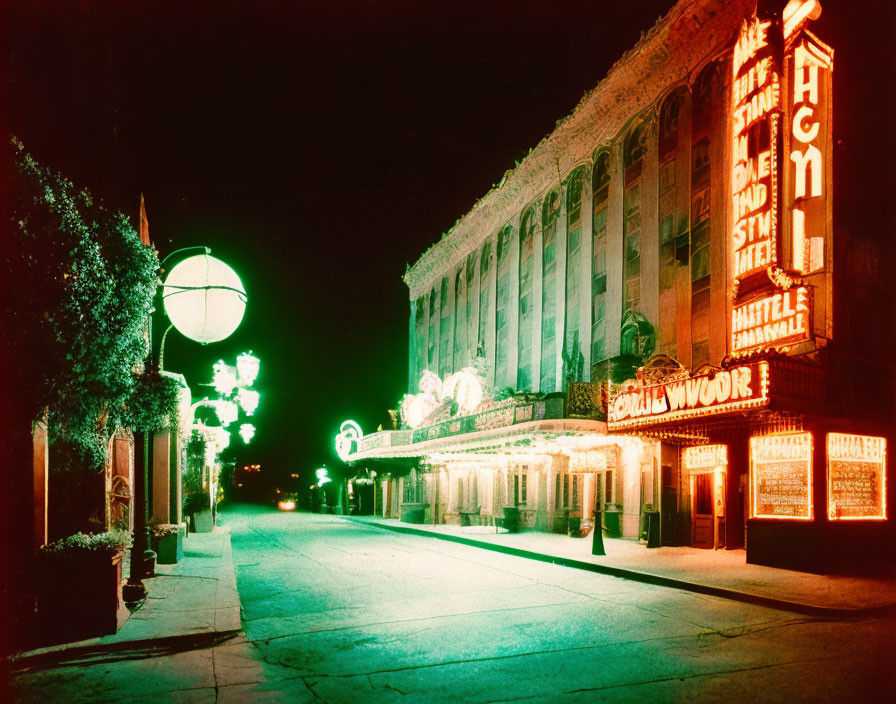 Vintage Nighttime Street View with Lit-Up Theater Marquee & Street Lamps