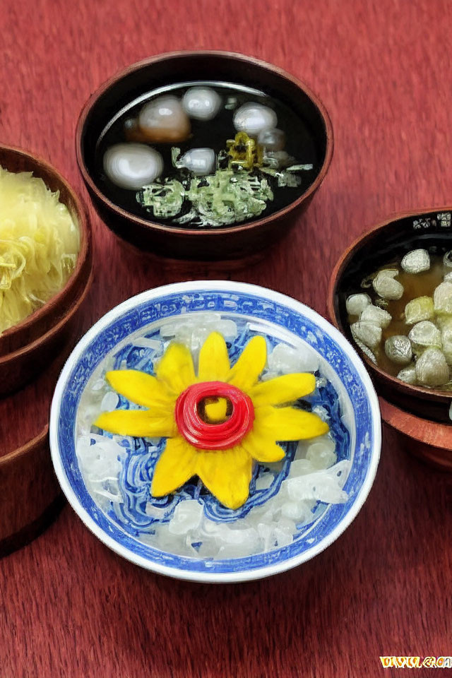 Three small bowls with beads and decorative flowers on red wooden surface.