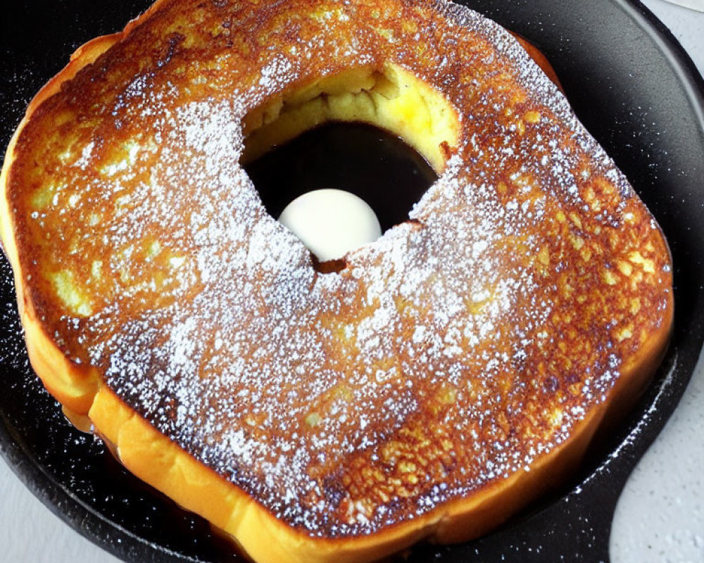 Circular Cutout French Toast with Powdered Sugar on Skillet