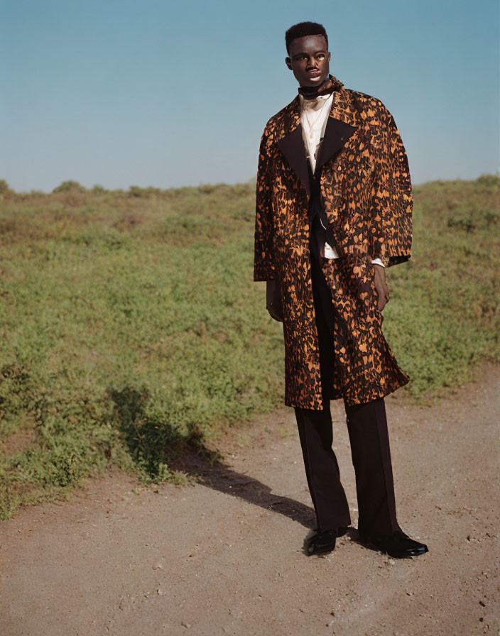 Elegant man in brown patterned coat on grass