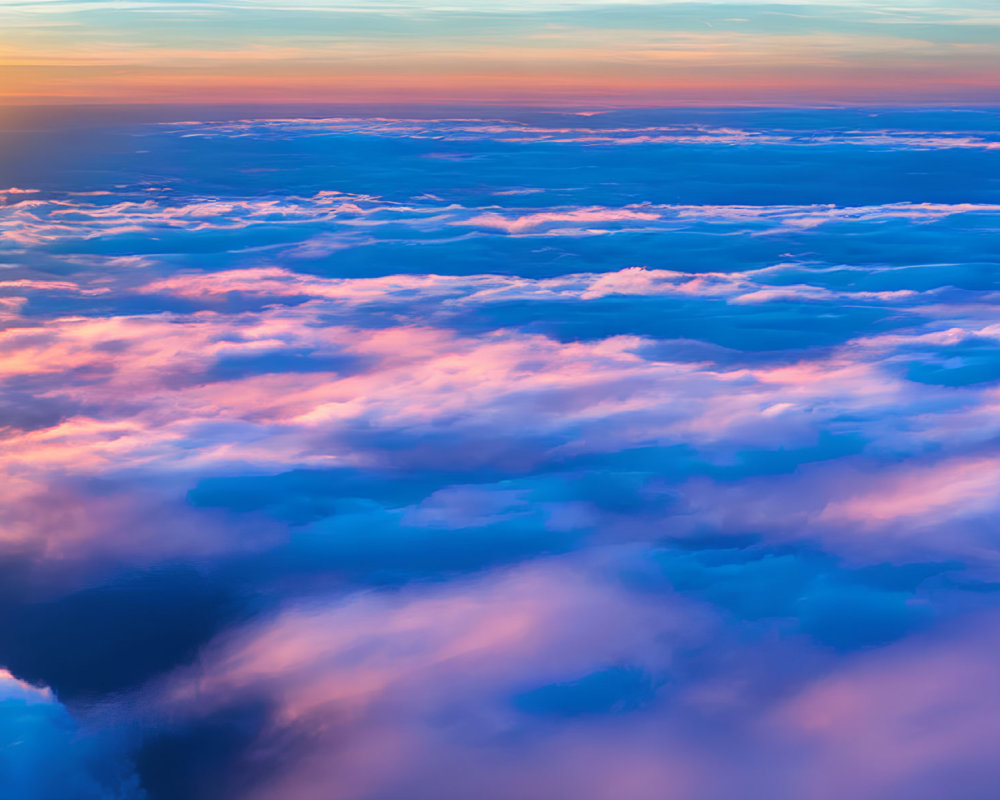 Vibrant Sunrise Over Sea of Clouds in Orange, Pink, and Blue Hues