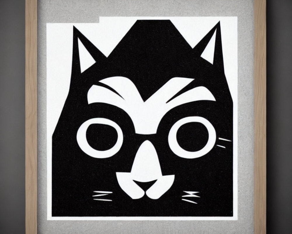 Black and white cat face art in wooden frame on gray background