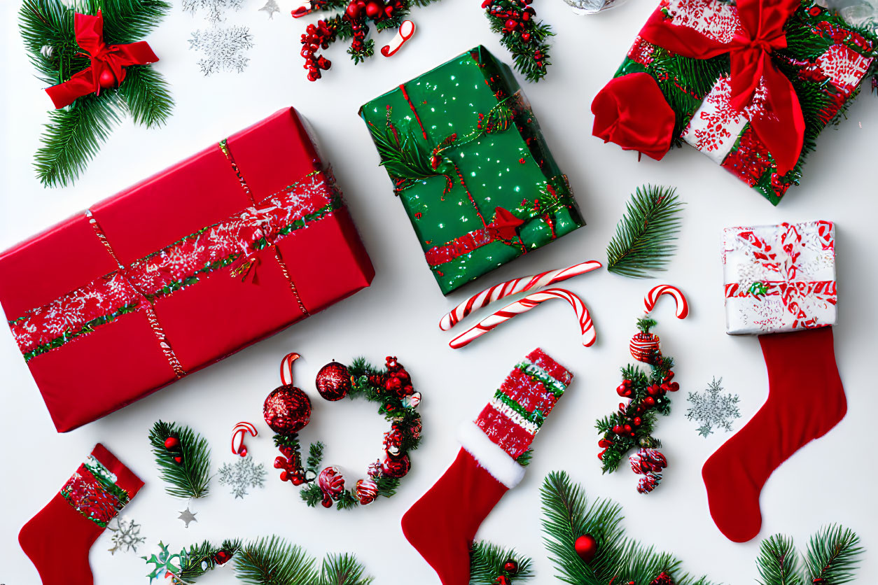 Festive Christmas gifts, decorations, candy canes, and stockings on white background