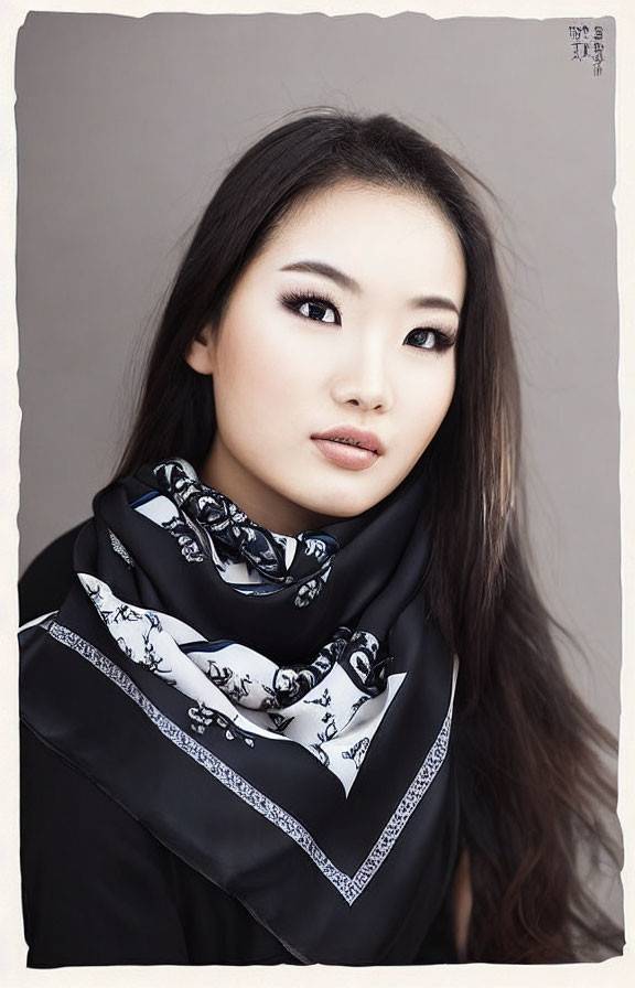 Young Asian Woman in Black Outfit with Patterned Scarf on Gray Background