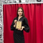 Regal woman with black hair and gold jewelry on ornate red background