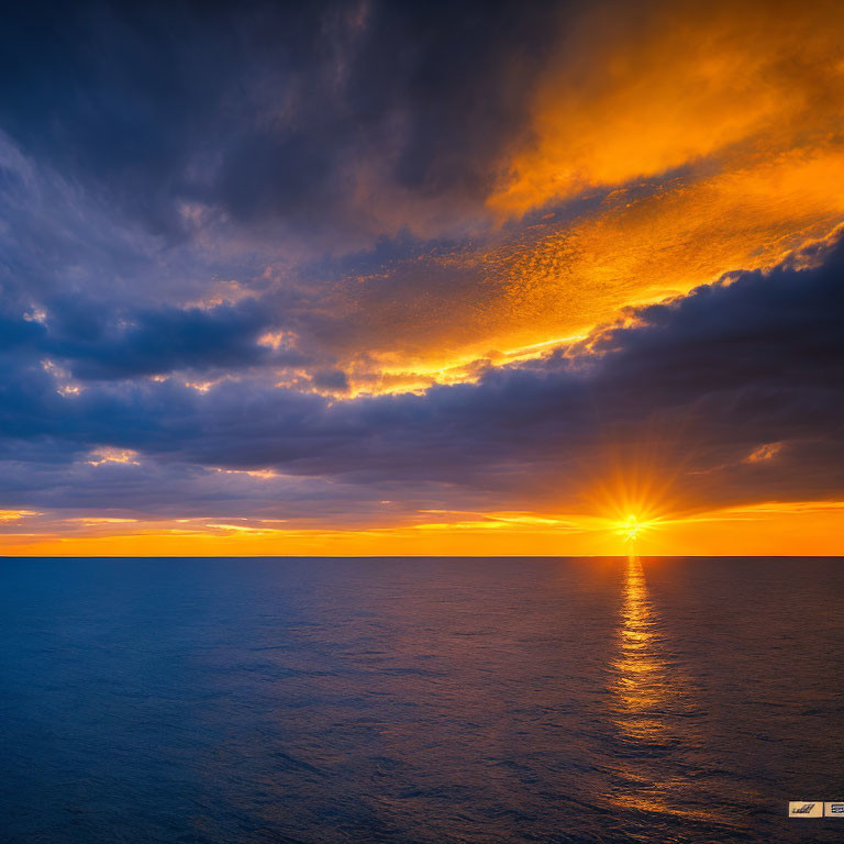 Vibrant ocean sunset with golden glow on clouds and sea