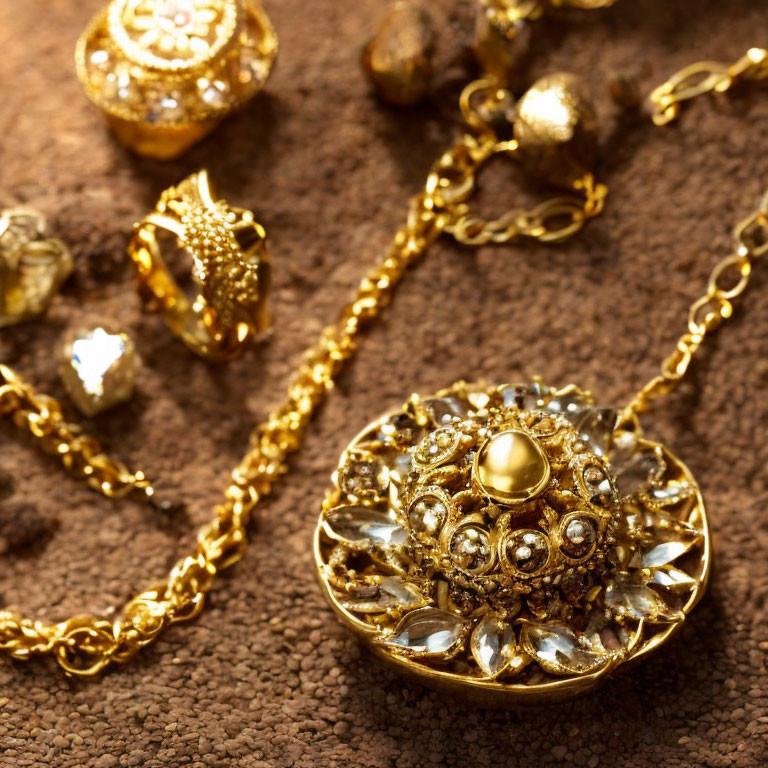 Ornate Gold Jewelry with Gemstones on Textured Surface